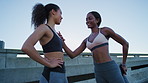 Women, friends and stretching for fitness in city with conversation, smile or story on bridge. Girl, happy and runner with discussion for exercise, circulation and chat with muscle warm up in town
