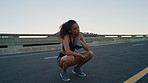 Woman, fitness and sweat with towel in city with rest for cardio, outdoor and fatigue on bridge. Girl, exhausted and break for exercise, sky and space in urban street with cloth for burnout in summer