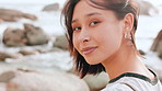 Wellness, windy or Asian woman at ocean with face, positive attitude or chill on weekend break. Peace, portrait or female person at beach with fresh air, good mood or outdoor getaway in New Zealand.