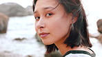 Wellness, face or Asian woman at ocean with wind, positive attitude or chill on weekend break. Peaceful, breeze or person at beach with portrait, fresh air or outdoor getaway in New Zealand.