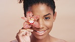 Face, skincare and black woman with flower, natural cosmetic and antioxidants for antiaging benefits. Happy, female person and orchid plant for dermatology, wellness and beauty on studio background.