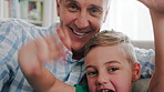 Face, grandfather and child wave on video call, smile and bonding with kid in living room. Portrait, boy and grandparent with online chat, greeting and happiness with POV of family in home together 