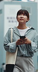 Happy, walking and Asian woman with phone in city for location, urban commute and travel on weekend. Outdoor, thinking and person on smartphone for connection, social media and direction in Japan