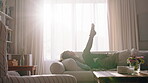 Young, child and play on couch with energy, kick feet and fun activity for entertainment on weekend. Girl, kid and movement in living room with legs up, wellness and childhood development in house.