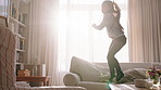 Girl, kid and jump on sofa with energy, fun activity and fatigue from entertainment on weekend break. Flare, young child play and bounce on couch with movement, freedom and tired in home living room.