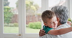 Excited, grandmother and boy with hug in home, weekend visit and funny conversation for family bonding. Laugh, pointing and senior woman with happy child for support, embrace or talk for relationship