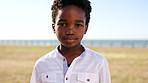 Face, nature and boy at promenade, kid and summer holiday to relax, travel weekend and sunshine. Outdoor, youth or black child with break, tourism or laughing with vacation, adventure or getaway trip