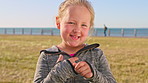 Travel, face or girl in park with smile, childhood holiday and fresh air on weekend break. Space, portrait or child on field with happiness, youth vacation and outdoor getaway in New Zealand.