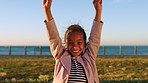 Face, kid and celebration in nature with dance, happy and target achievement with success. Outdoor, portrait and excited girl with victory, yes and child cheering for goal with reward by ocean