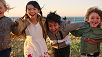 Hug, running and smile with children outdoor together for bonding, holiday or vacation as friends. Energy, fun and summer with group of excited kids on grass at beach for development or growth