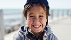 Face, laughing and child with headphones, beach and happiness on summer vacation or tourism on break. Outdoor, portrait and kid with humor on holiday, travel and excited with technology in nature