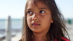 Face, serious and thinking with girl at beach for holiday break, travel or vacation in summer. Ideas, vision and windy with thoughtful child outdoor on promenade for contemplation or inspiration
