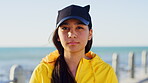 Cap, face and serious with girl on promenade at beach for holiday, travel or vacation in summer. Calm, hat and nature with confident teenager outdoor on boardwalk by ocean for weekend getaway