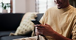Hands, phone and texting on sofa in home with smile, web chat or online dating in living room. Happy man, smartphone and typing on mobile app, laugh and meme with post on social network at house