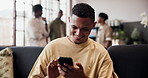 Funny, typing and man in home, smartphone for social media and digital app for communication. Smile, laughing and person on couch, happiness and cellphone for online humor and message to contact