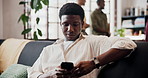 Happy, typing and man in home, cellphone for social media and digital app for subscription. Smile, laughing and person on sofa, funny meme and smartphone for online humor, relax or message to contact