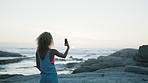 Picture, sunrise and woman on beach with phone for summer holiday, vacation and memories on weekend. Travel, nature and person by ocean with photos for social media, online post and scenic view