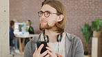 Phone, smile and thinking with designer man in office for communication, development or planning. App, ideas and scrolling with happy employee in design workplace for inspiration or research