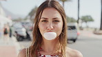 Travel, summer and face of girl with bubble gum on city street for holiday, vacation or weekend in break. Portrait, tourist and blowing bubbles with happy woman, smile and laugh for trip in Miami