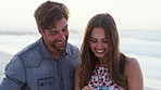 Happy couple, phone and laugh with post at beach on vacation, bonding or funny video in summer. People, smartphone and partner with mobile app, notification and social network on holiday at seaside