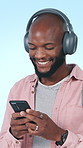 Headphones, phone and black man in studio with music for positivity, good mood and relax on weekend. Student, streaming and person listening to audio, radio and playlist for energy on blue background