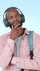 Thinking, student and man with headphones, education and plan for exam with podcast on social media. Blue background, knowledge and black person with tech for audio, streaming or reflection in studio