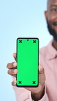 Face, green screen and black man with smartphone, closeup or social media on blue studio background. Internet, mobile user and person with cellphone, network and app for communication and contact