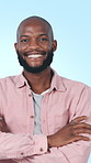 Face, fashion and black man in studio with arms crossed, smile or casual clothes for trendy aesthetic. Confident, person and happy with shirt, cool style and positive attitude on blue background.