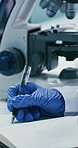Microscope, hands and scientist in laboratory for writing notes with medical research, study or project. Gloves, professional and female biologist with biotechnology for pharmaceutical breakthrough.