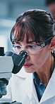 Science, goggles or woman in lab with microscope, study or examination in vaccine development. Medical, glasses or mature scientist with equipment, research or investigation in clinical trial.