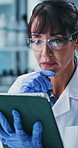 Scientist, woman and reading in lab with tablet, test results and problem solving for medical research. Mature person, thinking and science report in clinic with tech, insight and healthcare study.