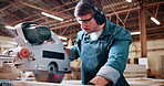 Bandsaw, carpentry and earmuffs with man in warehouse for manufacturing or production process. Eyewear, ppe and sawing machine with person in woodworking plant to resize lumber or timber for project