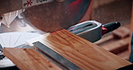 Wood, saw and workbench with carpenter for precision cut, timber project or craft furniture. Person, blade and slice with lumber plank, power tool or machine for carpentry, woodwork or manufacturing