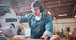 Bandsaw, carpentry and earmuffs with man in plant for manufacturing or production process. Eyewear, ppe and sawing machine with person in woodworking warehouse to resize lumber or timber for project