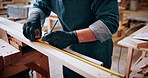 Man, hands and carpenter with measuring tape for lumber project, furniture or accuracy in workshop. Male person, measurement or pencil marking on wood plank for timber fit, precision or dimension