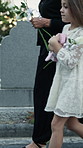 Grandmother, walking and child at graveyard for funeral ceremony, burial service and mourning loss. Person, kid or flowers for condolences, emotional ritual and tribute gathering at farewell memorial
