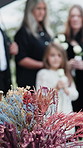 Blur, flowers and casket at cemetery for funeral, service and family with solidarity for mourning. People, group or floral bokeh with ritual, coffin and religion with burial ceremony at graveyard