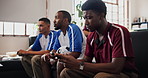 Friends, watching tv or man with mobile in home for research, soccer player stats or sports betting. Distraction, typing or people with football match broadcast, phone or line up news on social media