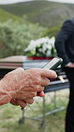 Funeral, chat and hands outdoor with phone, family arrangements or update on reception details. Digital, scroll or person outside with tech, ceremony agenda or online conversation at memorial service