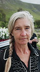 Face, sad and old woman in graveyard with funeral, people mourning and grief for burial ceremony. Senior person, death and sorrow at cemetery outdoor with memorial service, bereavement and farewell.