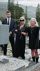 Memory, sad and family in cemetery with grief, support and remembrance together in mourning. Emotional, women and man at gravestone with loss, unhappy and shared bereavement with memorial visit.

