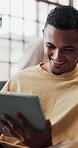 Man, tablet and smile on sofa for social media, communication or entertainment in home living room. Male person, laugh and relax on lounge couch with technology for online streaming and scroll