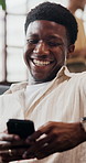 Mobile, relax and man in home with funny message, social media or reading notification on internet. Phone, laugh and person in living room with meme on app, text or typing for online communication
