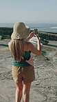 Photography, harbor and back of woman outdoor on holiday, getaway or weekend trip by seaside for sightseeing. Phone, walking and person with picture for memory, social media or blog post on vacation.