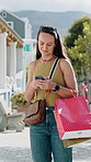 Cellphone, happy and woman with shopping bag in city for networking, texting or retail therapy. Smile, technology and female person with cellphone for website discount, promotion or sale in town.