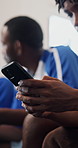 Hands, phone and texting with soccer team in locker room for chat, contact and break at sports club. Men, group and smartphone with scroll, typing or notification on mobile app with football players