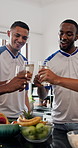 Men, friends and toast with glasses in home for celebration, reunion or party with football shirt for game. People, group and drinks with beverage, alcohol or bonding for sports tournament at house