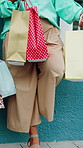 Friends, hands and women with shopping bags at wall for fashion discount, clearance sale or special. Legs, shoppers and designer gifts outdoor for boutique promotion, retail deal or clothing purchase
