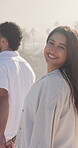 Face, woman and couple on beach with summer holiday, holding hands and smile for bonding together. Happy, married people and walk outdoor by ocean with love, tropical vacation and travel adventure.
