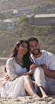 Couple, smile and holding hands on beach with summer holiday, connection or relax for bonding together. Happy, married people and peace by ocean with love, tropical vacation or discussion for travel.